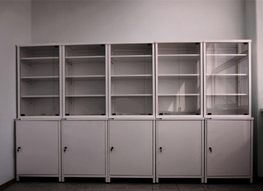 Na zdjęciu przedstawione szafy laboratoryjne przeszklone na szkło i dokumenty