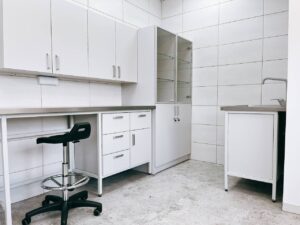 Na zdjęciu przedstawiono szafki laboratoryjne wiszące i stół laboratoryjny JORLAB z blatem ze stali nierdzewnej